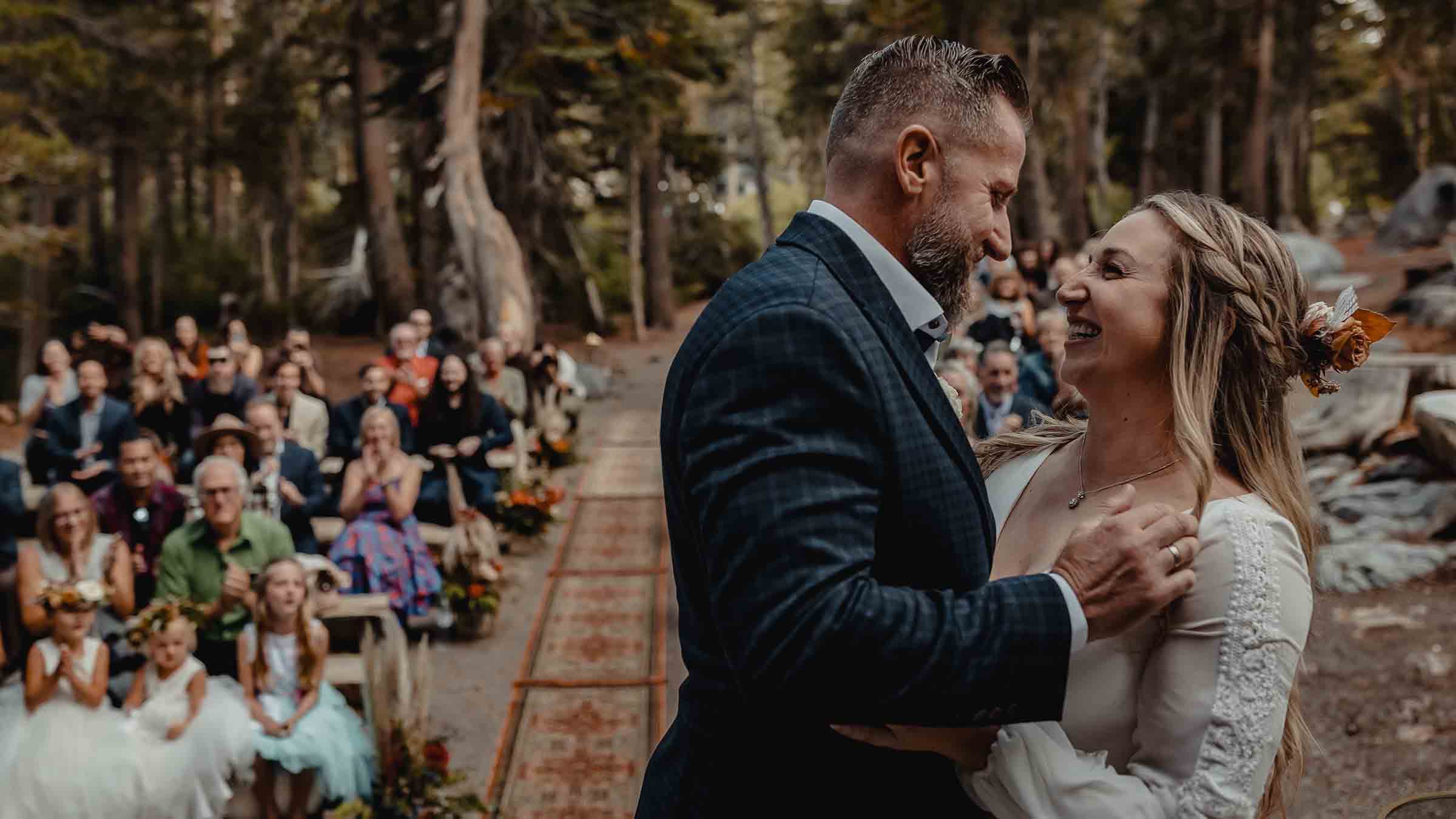 A couple smiling at Forest Chapel as their guest watch